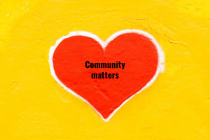 A red heart on a yellow wall proclaims community matters