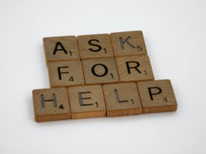 Wooden scrabble tiles spell out 'ask for help' in relation to discussing care options